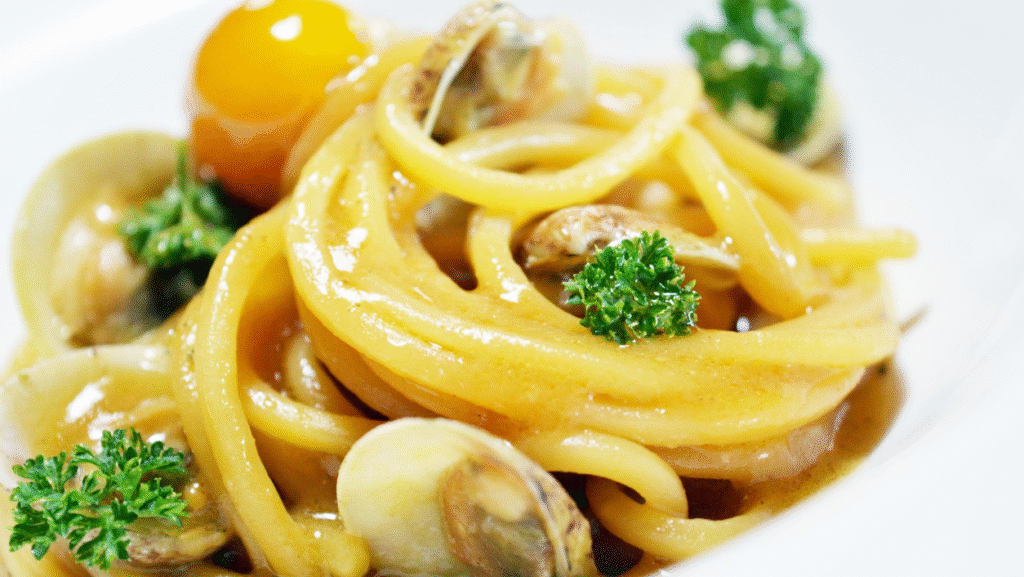 Spaghettone di Gragnano, crema di acqua di lupini, datterini gialli, colatura di alici Delfino e limone